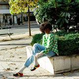 Black woman wearing Swedish clogs worn with off-white colored cashmere socks, blue jeans. and our Ursula sweater.