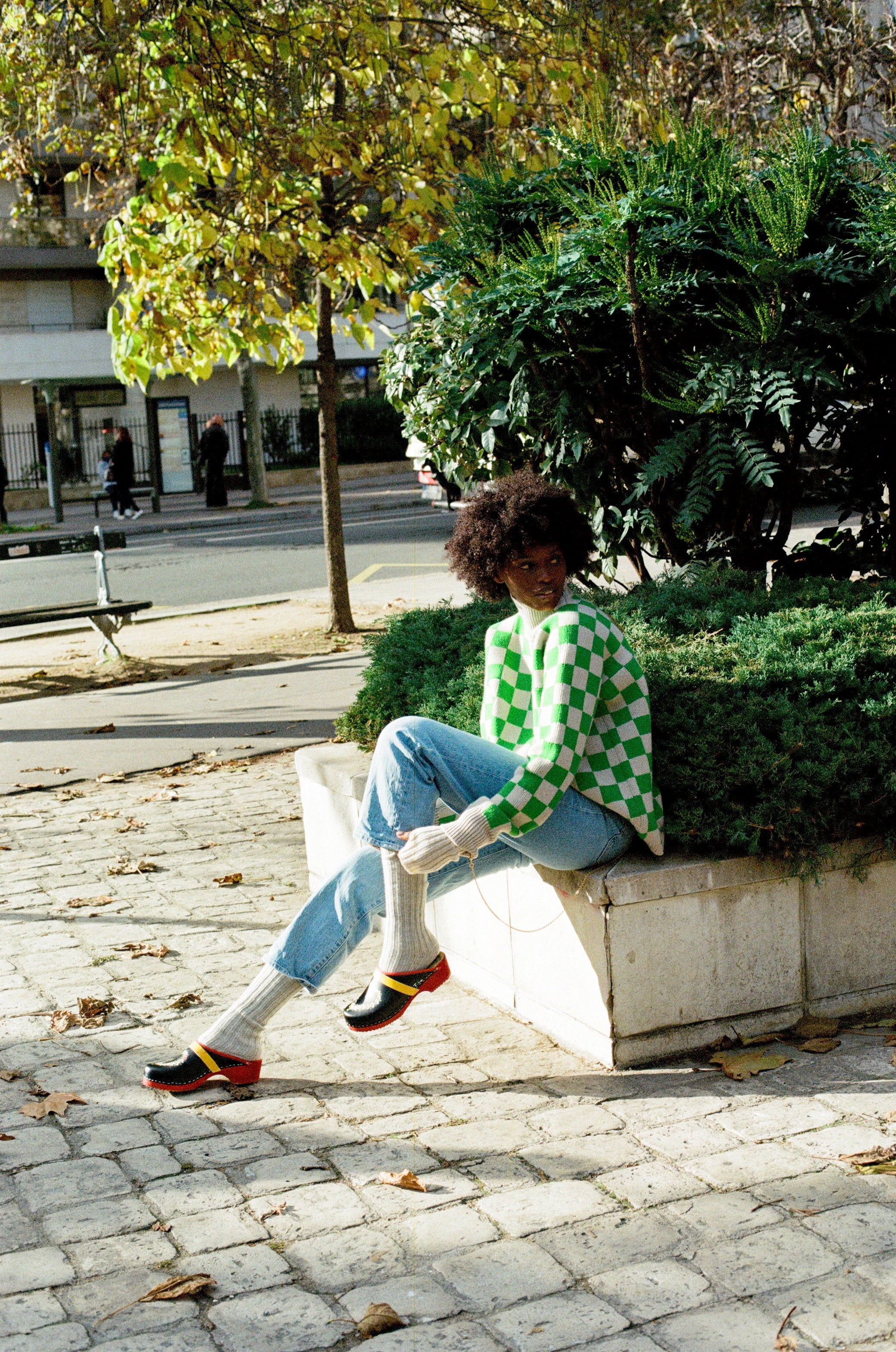 Black woman wearing Swedish clogs worn with off-white colored cashmere socks, blue jeans. and our Ursula sweater.
