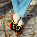 Swedish clogs worn with off-white colored cashmere socks and blue jeans.