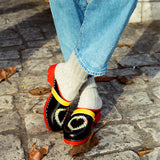 Swedish clogs worn with off-white colored cashmere socks and blue jeans.