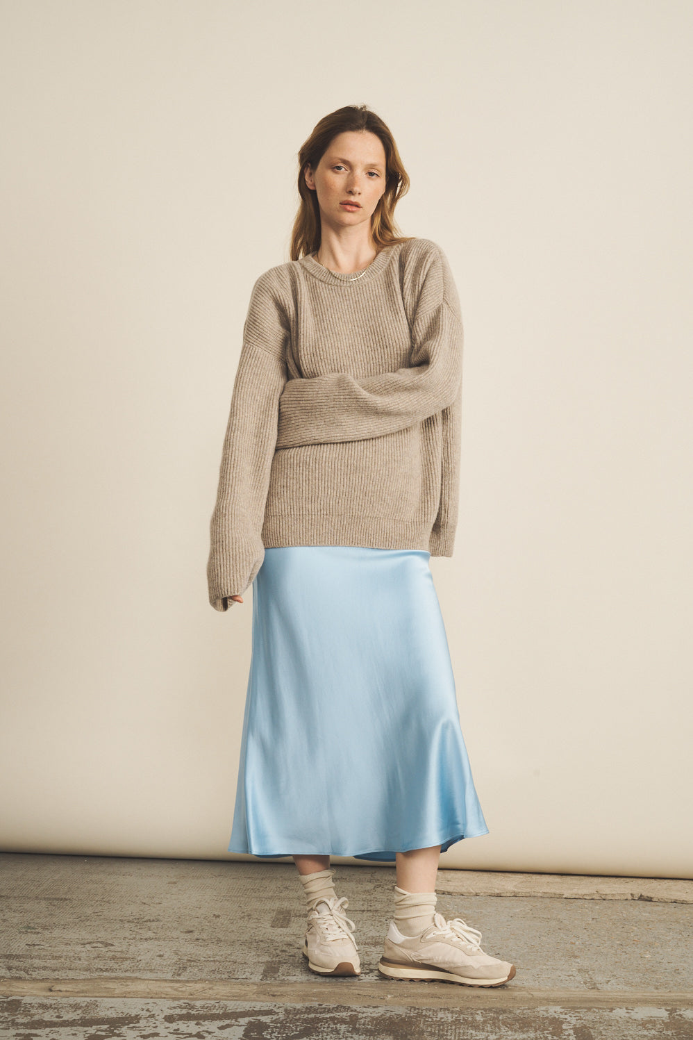 Women's casual chic look, oversized beige cashmere sweater with long sleeves and blue skirt with sneakers | Edward | Linnea Lund